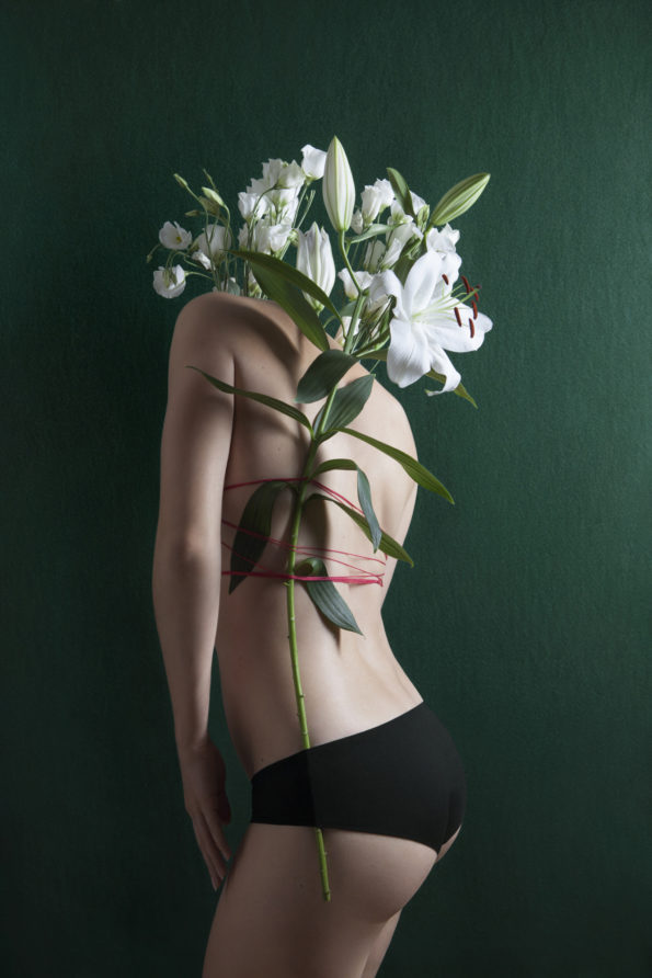 Sur un fond vert, on voit le 3/4 dos d'une femme, peu vêtue, à laquelle est attachée une seule tige se prolongeant en un large bouquet de fleurs blanches s'épanouissant à hauteur de ce qui serait la place de la tête de la femme, cette tête ne se distingue pas et est donc remplacée par ce bouquet de fleurs.